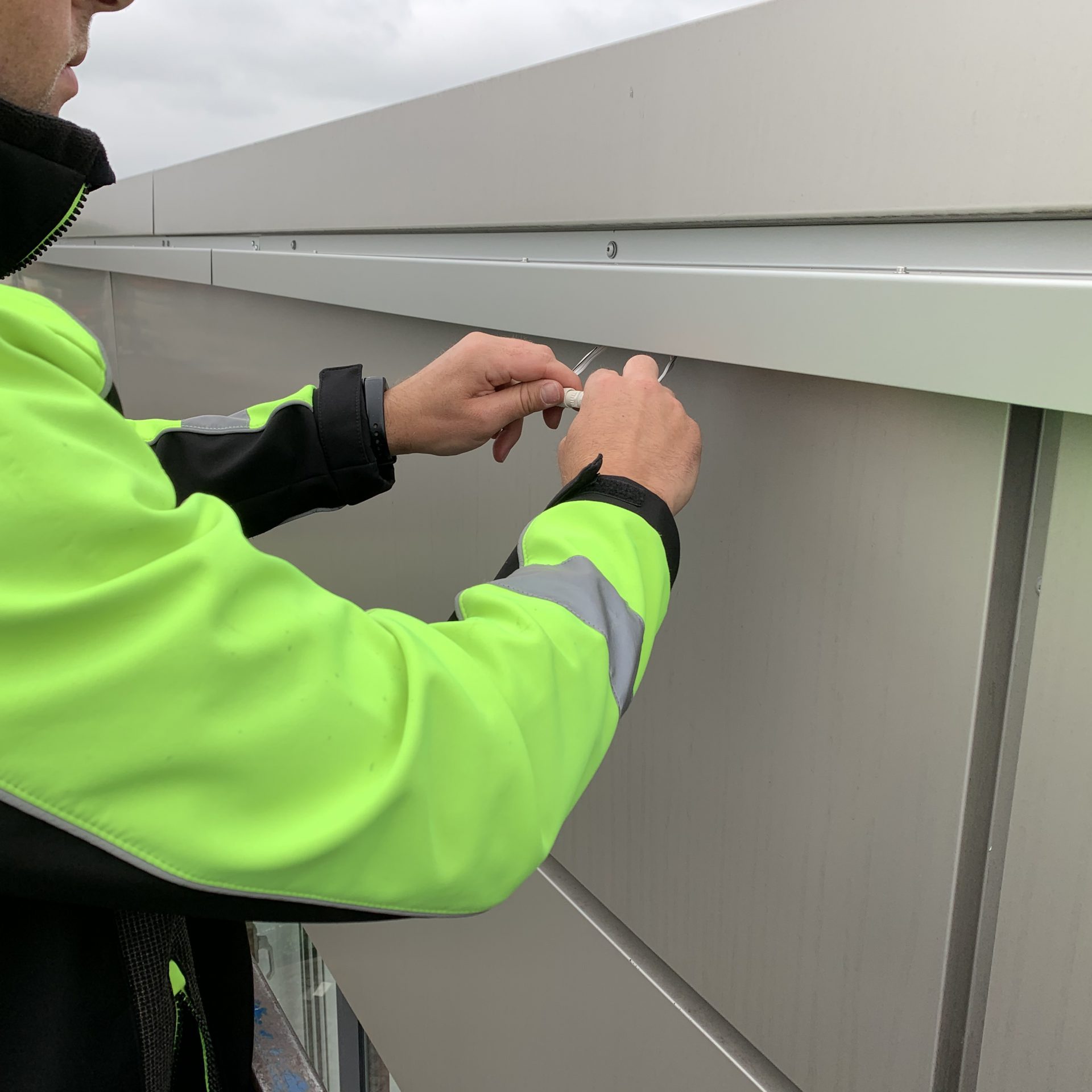 Installatie van de led verlichting aan de gevel van het bedrijfspand